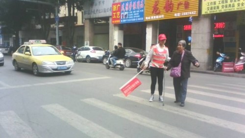 图二我校志愿者扶老人过马路_conew1.jpg